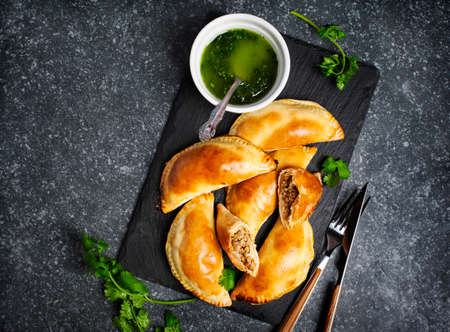 Empanadas with chimichurri sauce. Latin American tradition cuisine. Top view, copy spaceの写真素材