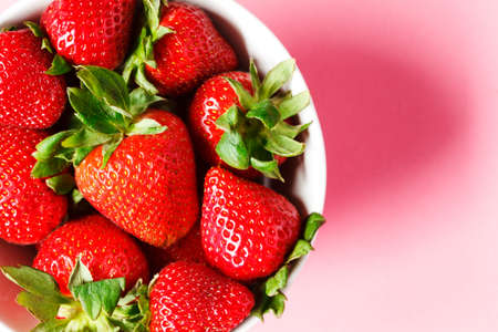 Strawberries in bowls on pink background, top view, copy spaceの写真素材