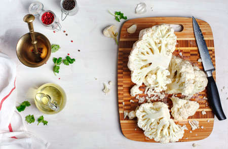 Fresh cauliflower on wooden cooking board, top view, copy space