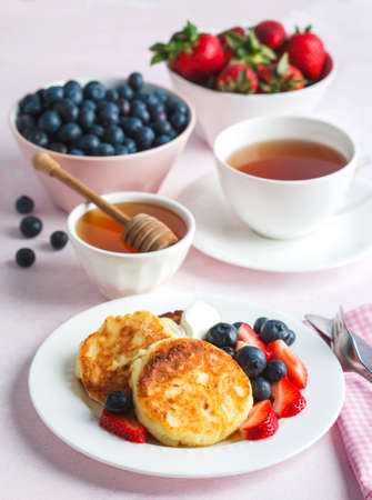 Cottage cheese pancakes with honey and berries for breakfast or lunchの写真素材