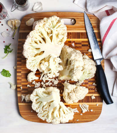 Fresh cauliflower on wooden cooking board, top view.の写真素材