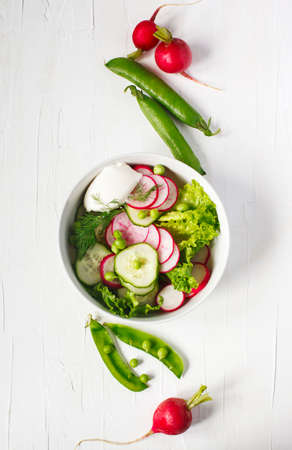 Spring vegetable salad with radish, cucumber and green peas, top viewの写真素材