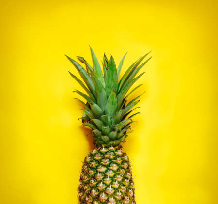 Fresh pineapple on yellow background, top viewの写真素材