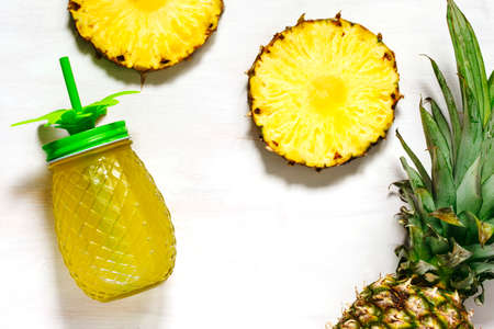 Pineapple juice and slices of fresh pineapple, top view, copy spaceの写真素材