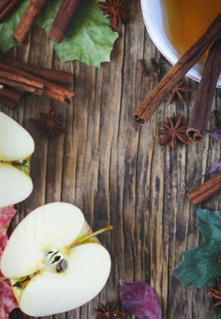 Autumn frame wth tea, apple, cinnamon stick, star anise and clove, copy space, top viewの写真素材