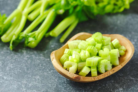 Fresh sliced celery in a wooden bowlの写真素材