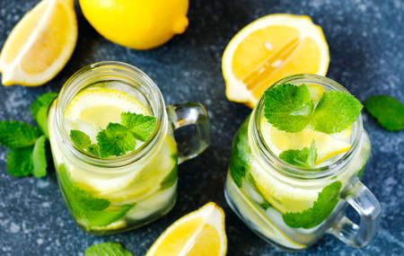 Mason jar glass of lemonade with mint on blue stone background, copy spaceの写真素材