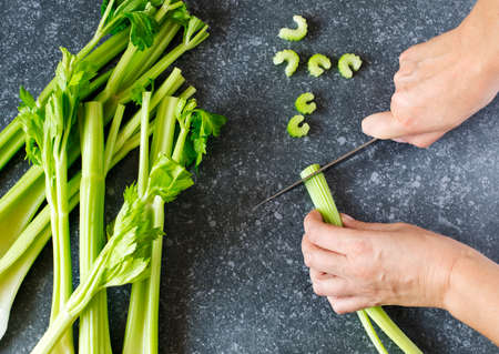 Woman cutting a fresh celeryの写真素材