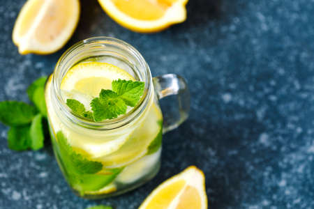 Mason jar glass of lemonade with mint on blue stone background, copy spaceの写真素材