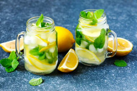 Mason jar glass of lemonade with mint on blue stone background, copy spaceの写真素材