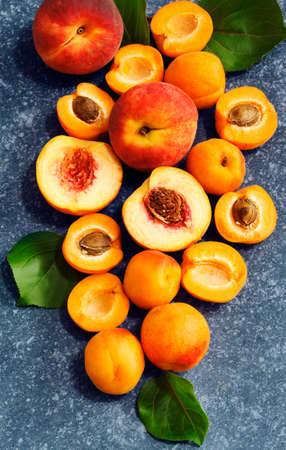 Apricots and peaches on blue stone background, top viewの写真素材