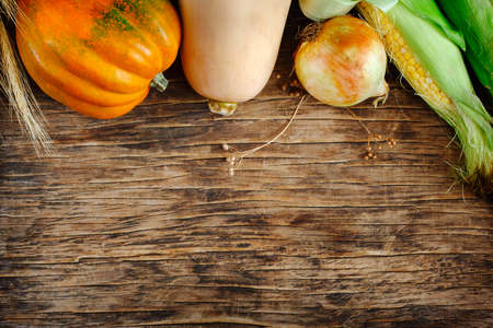 Organic autumn vegetables. Assortment of raw vegetables on a wooden background. Healthy nutrition concept. Top view with copy space.の写真素材