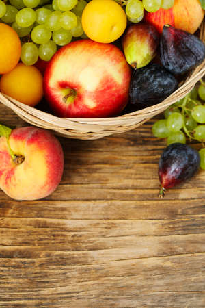 Autumn fruits in basket on wooden background witn copy spaceの写真素材