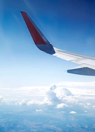 View from the airplane window. Airplane flying above the clouds in the skyの写真素材