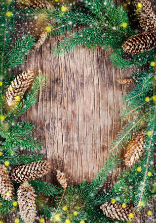 Christmas background with spruce branches and pine cones on wooden background.の写真素材