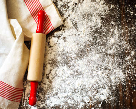 Classic wooden rolling pin and dusting of flour on wooden backgroundの写真素材