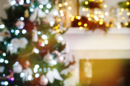 Christmas tree and fireplace with festive bokeh lighting, blurred holiday backgroundの写真素材