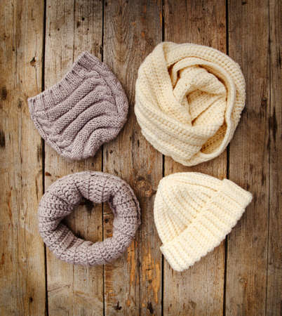 Knit Wool Hats ans Scarfs on wooden background, top viewの写真素材