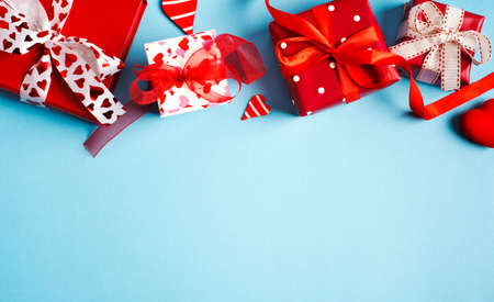 Holiday gifts. Red gift boxes on blue background. Valentines day concept. Top view, copy spaceの写真素材