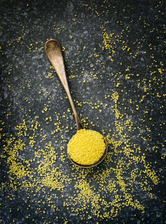 Uncooked couscous in spoon, top view