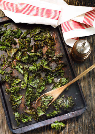 Kale chips with sea salt on baking trayの写真素材