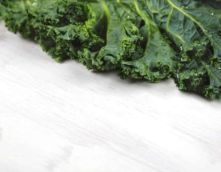 Freshness kale leaves on a white wooden background, top view.の写真素材