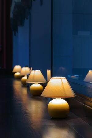 Row of tables and lamps in restaurantの写真素材