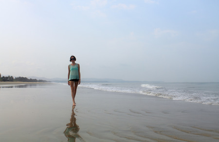 beautiful girl walking on the beachの写真素材