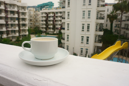 Cup of black coffee with milk on the background of the poolの写真素材
