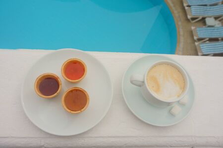Cup of black coffee with milk on the background of the poolの写真素材