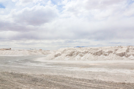 Pile of white sand in the desert with blue sky and white cloudsの写真素材