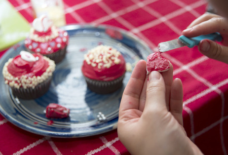 making homemade valentine cupcakes with sweet and delicious toppingsの写真素材