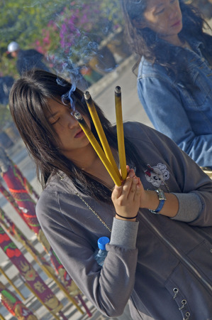 Hongkong, China, 04 December 2006: woman burning incense at Po Lin monestaryのeditorial素材