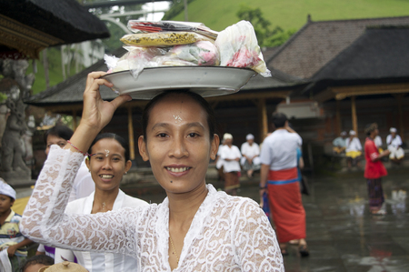 Woman walking with offering baskets on their heads at Tirta Empul Tempel Bali Indonesiaのeditorial素材