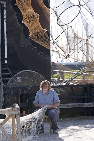 Enkhuizen, The Netherlands,10-09-2016: Fisherman fixing his netsのeditorial素材