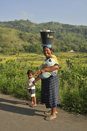 woman walking along the road with child, Indonesiaのeditorial素材