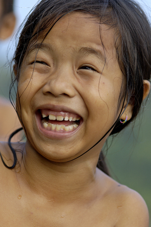 Laos-okt-30. Smiling Laos girl in her traditional village along the Mekong river were she is washing herself 30-10-2007のeditorial素材
