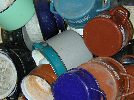 A messy collection of old rustic pots and pans.