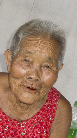 Chang Mai, Thailand - May 28, 2011: An old woman smiling for the camera in Chang Mai.のeditorial素材