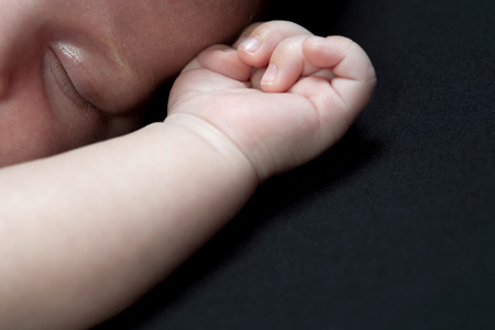 motherhand and babyhand isolated on a black backgroundの写真素材