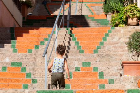 Castelsardo, Sardinia,16-10-2021, boy climbing steps to castle.