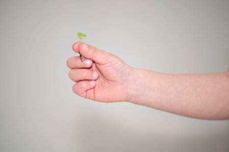 Person holding a seedling in hand, showing it with a gentle gesture