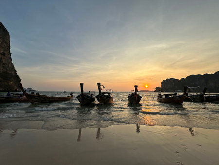 A collection of boats can be seen in the water at sunsetの写真素材