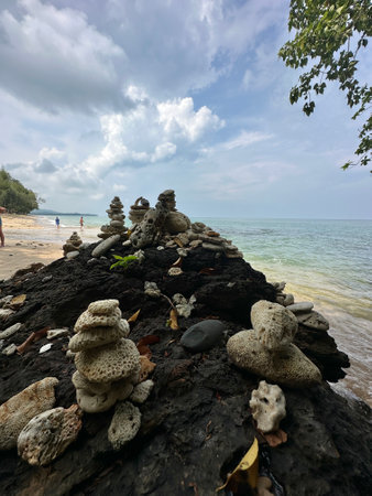 There is a substantial pile of rocks located on a beach beside the oceanの写真素材