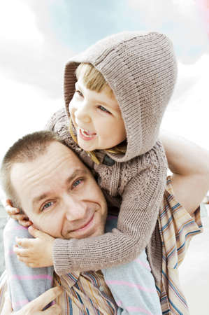 A father holding his happy daughter on his shoulder.の写真素材