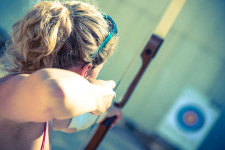 Young woman aiming with a bowの写真素材