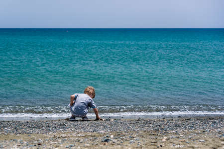 Boy playing with stones on a beach