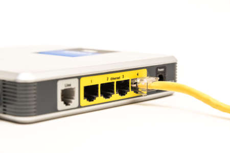 A yelow ethernet cable connected to a network router isolated