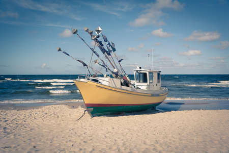 An old fishing boat docked on a sandy beach, vintageの写真素材