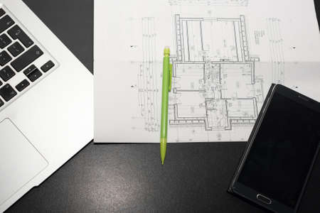 Laptop, smartphone, pencil and paper with drawings on a black desk - architecture design conecptの写真素材